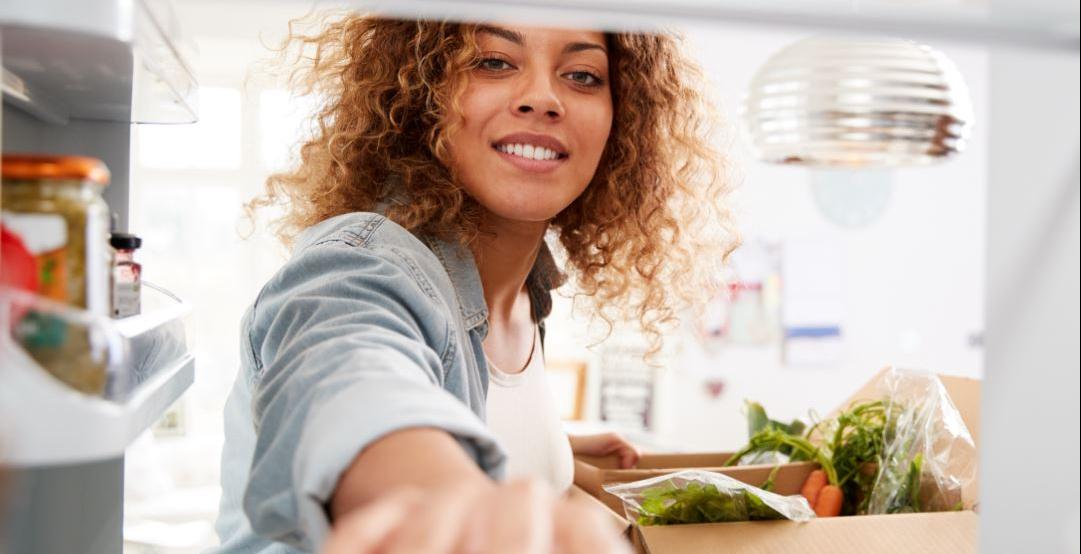 Woman taking food from fridge