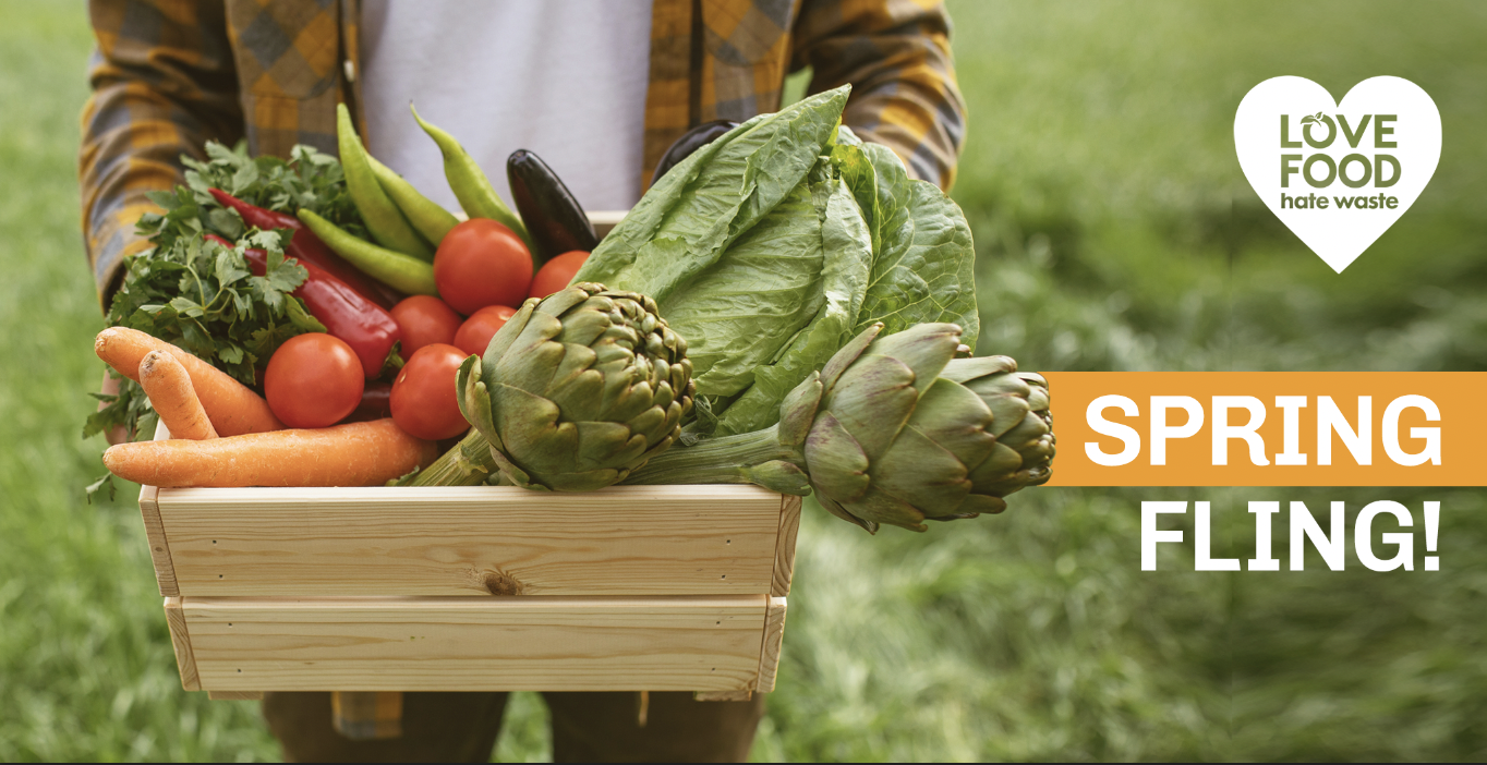 person holding an overflowing box of spring produce